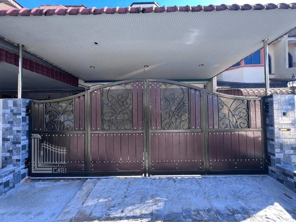 Mild steel folding gate with welded decorative scrollwork panels at a house in Perak, Malaysia