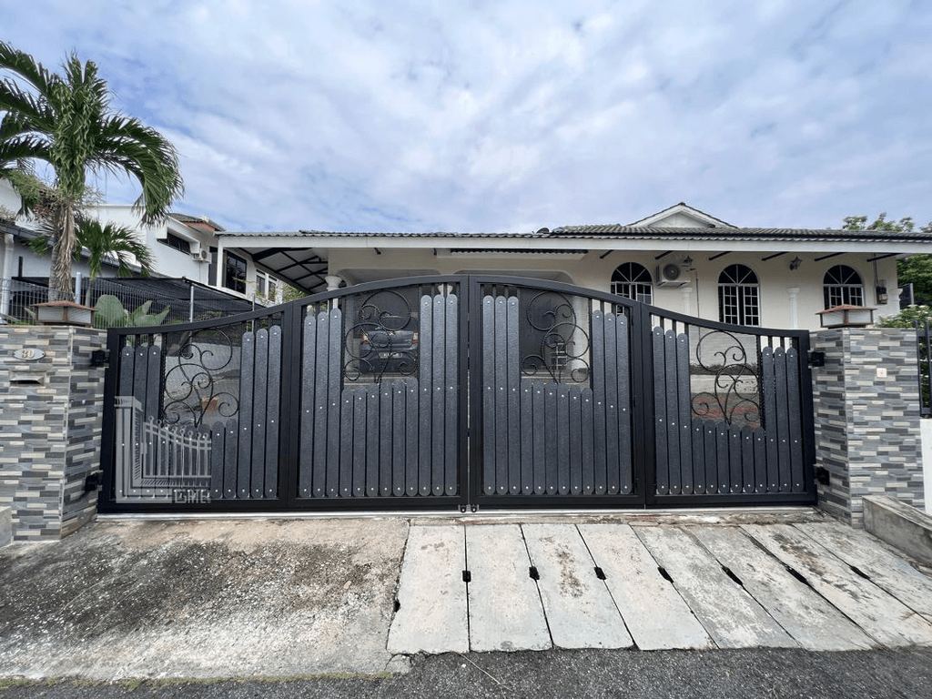 Folding gate with decorative scrollwork panels on masonry pillars at a house in Ipoh, Perak, Malaysia